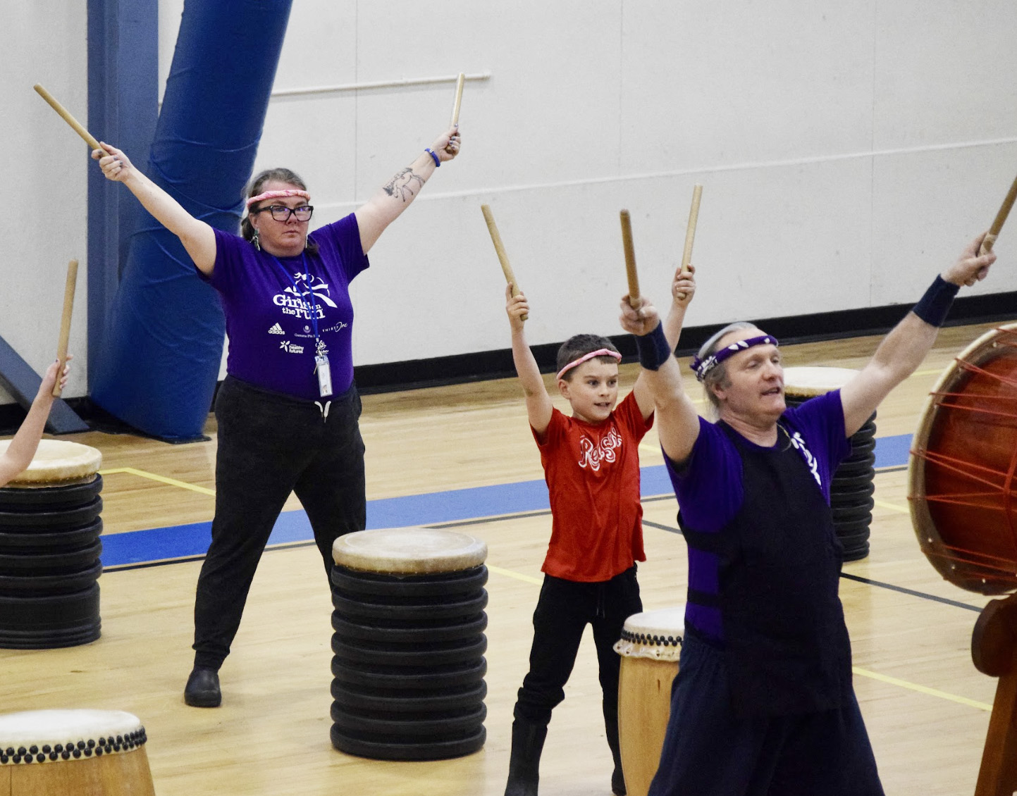 students and teacher playing drums